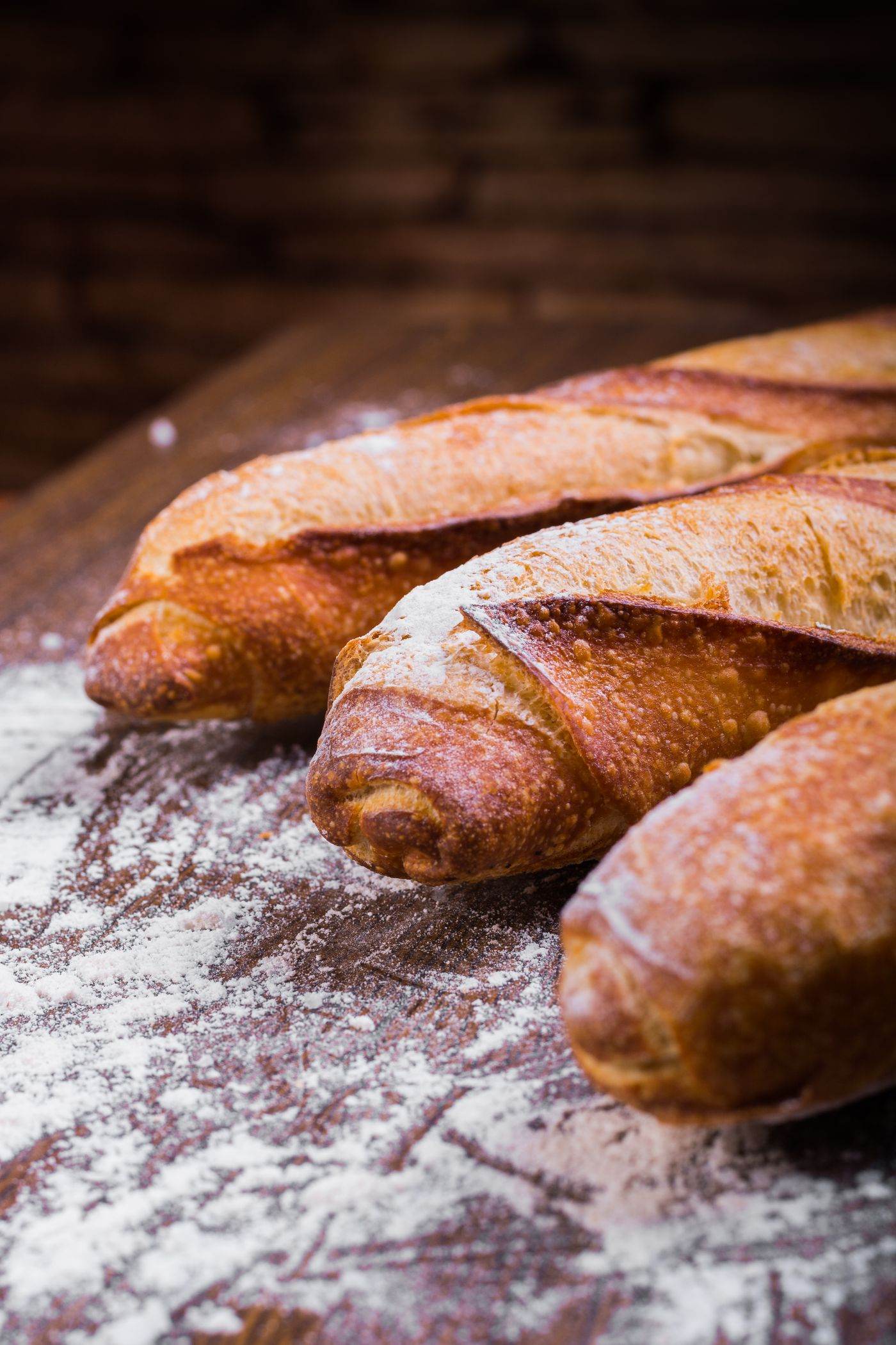 Baguettes lined up on a board.